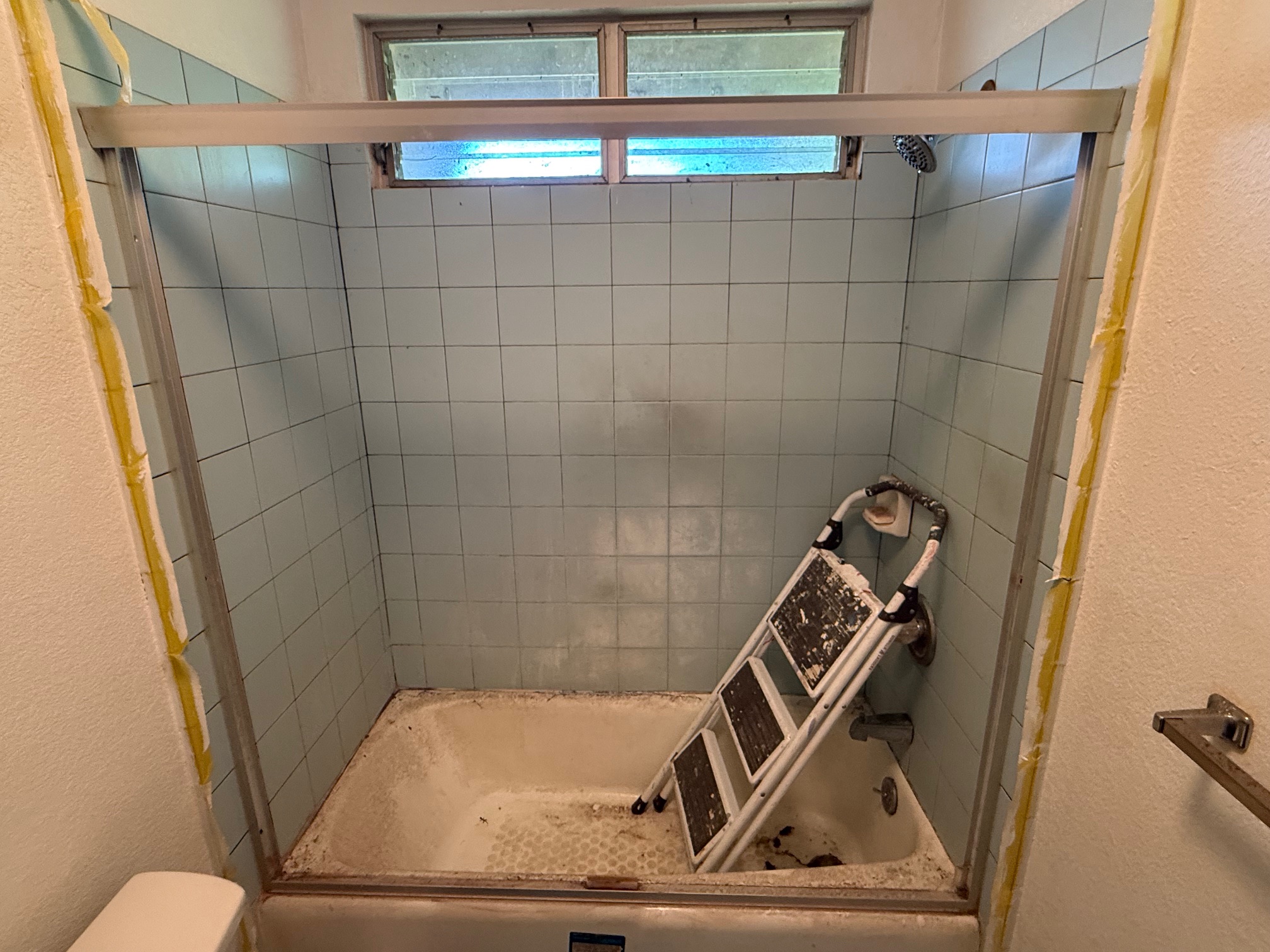 Getting on step-stool and painting around the tub area with semi-gloss Benjamin Moore paint from City Mill ($60/gallon plus tax). Need to redo the window ledge as it's falling apart. 