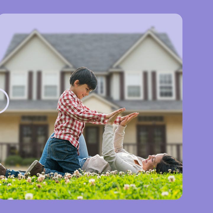 A woman plays with a child on the lawn in front of a white, two-story house. The image has a purple border.